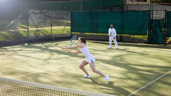 Lady playing tennis courts at St George's Hill Lawn Tennis Club Surrey